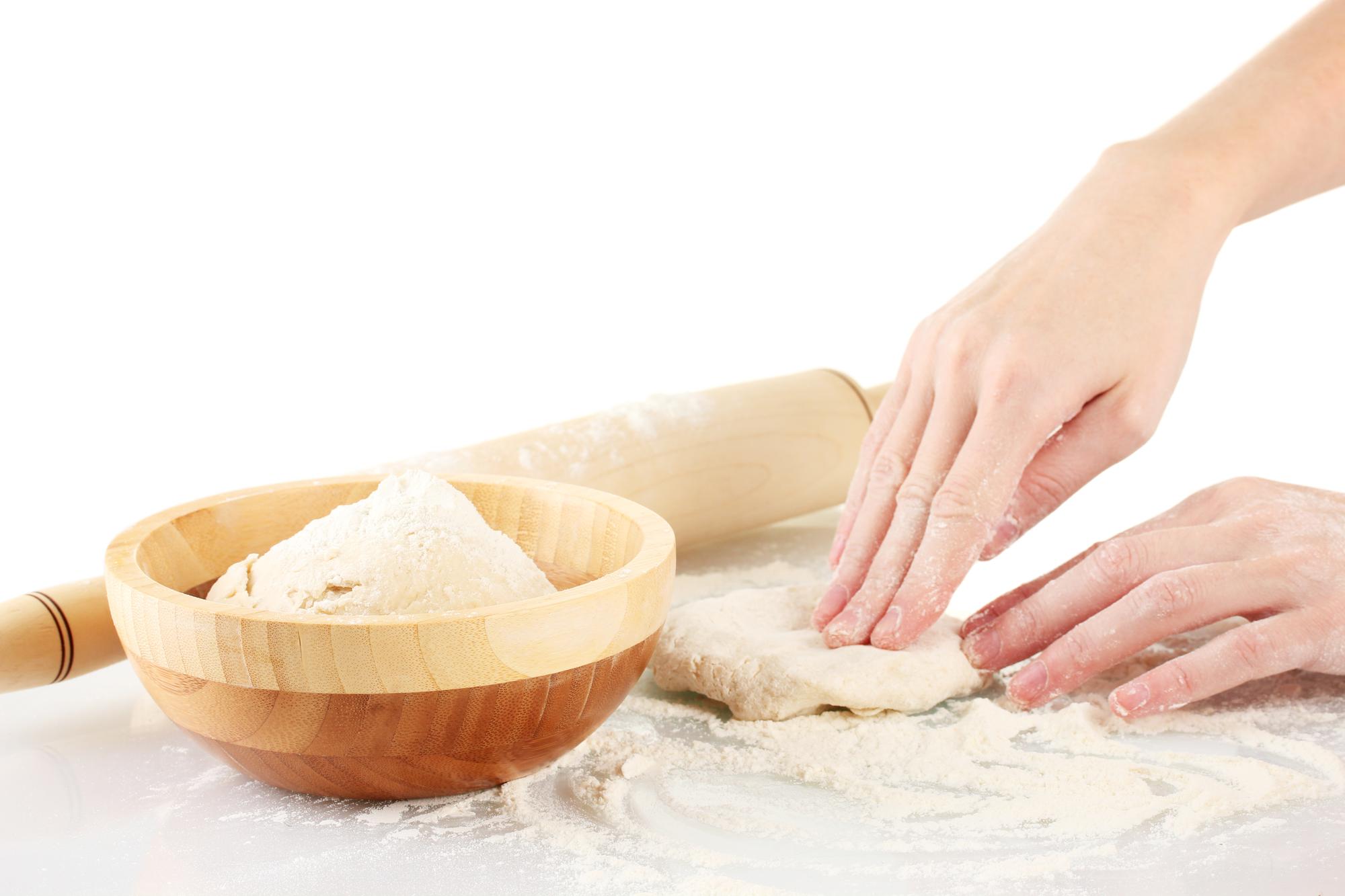 Mani che impastano pane artigianale